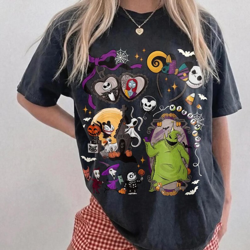 May include: Dark grey t-shirt with a vibrant graphic of characters from "The Nightmare Before Christmas." The design includes Jack Skellington, Sally, Oogie Boogie, and other Halloween Town elements. The shirt has a classic crew neck and short sleeves.