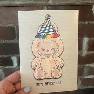 Labubu Happy Birthday Sisi - Carte d'anniversaire LES MONSTRES s'assoient