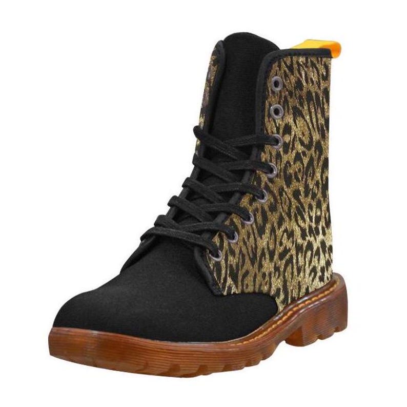 May include: Black canvas boots with a gold and black leopard print design by artist Shayne of the Dead. The boots have a lace-up closure and a chunky rubber sole.
