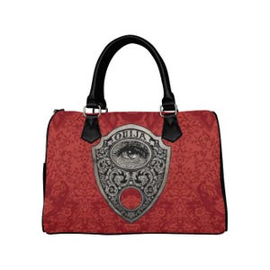 Può includere: Borsa a mano rossa a tema Ouija con manici e dettagli neri. La borsa presenta uno scudo decorativo argentato con un occhio e la scritta "OUJIA". La borsa ha un motivo floreale.