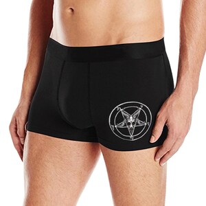 May include: Black boxer briefs with a white pentagram and goat head design. The underwear is made of a soft, stretchy material.