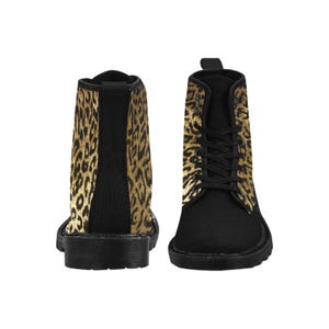 May include: Black canvas boots with durable black rubber soles and a leopard print design on the upper part of the boot. There is a yellow pull loop on top of the back of each boot.