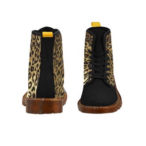 May include: Black canvas boots with durable brown rubber soles and a leopard print design on the upper part of the boot. There is a yellow pull loop on top of the back of each boot.