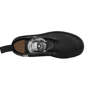 K&ouml;nnte beinhalten: Schwarze Lederstiefel mit einem grafischen Aufdruck eines Gesichts auf der Seite. Das Gesicht ist in Schwarzwei&szlig; gehalten und scheint ein Monster zu sein.