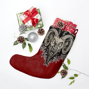May include: A red Christmas stocking with a black and white illustration of a horned demon with a menacing expression. The stocking is decorated with flames and is filled with wrapped gifts.