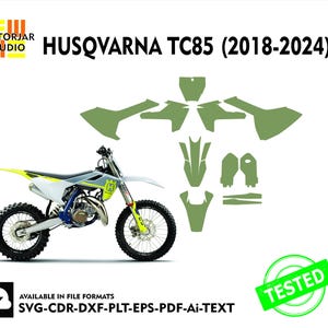 Op de afbeelding: Een witte, blauwe en gele Husqvarna TC85 motorfiets met zwarte banden en een groene decalset. De afbeelding bevat de tekst "HUSQVARNA TC85 (2018-2024)" en "TESTED". Beschikbaar in SVG-, CDR-, DXF-, PLT-, EPS-, PDF- en Ai-bestandsformaten.