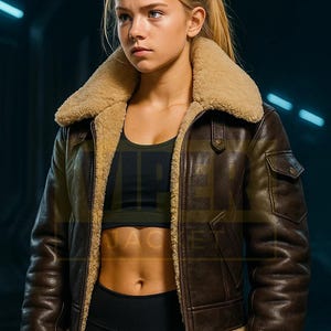Puede incluir: Chaqueta de cuero marrón con cuello y forro de borrego beige. La chaqueta tiene cierre de cremallera, un pequeño bolsillo en el pecho y puños de borrego. El logo "VIPER JACKET" está en la esquina superior izquierda.