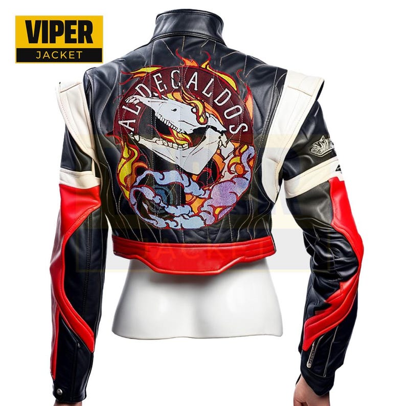 Puede incluir: Chaqueta de cuero negra con detalles rojos y blancos. La parte posterior de la chaqueta presenta un gran parche bordado con una calavera y llamas. El parche dice "ALDECALDOS".