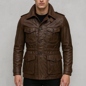 May include: A brown leather jacket featuring four front pockets, a button-up closure, and a collared neckline. The jacket has a tailored fit and is worn over a black shirt. The design includes shoulder epaulettes and buttoned cuffs.