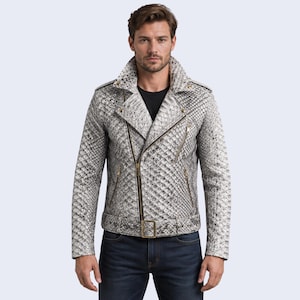 May include: A motorcycle jacket featuring a textured, snakeskin-patterned finish in shades of grey, white, and black. The jacket includes a wide notched collar, an asymmetrical front zipper closure, gold-toned hardware, and a buckled belt at the waist.