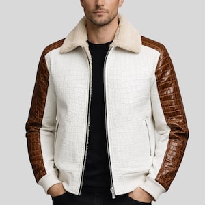 May include: White bomber jacket with brown crocodile-textured sleeves and accents. The jacket features a cream-colored shearling collar and a full-length zipper. The jacket has a textured pattern throughout the white sections.