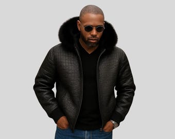 May include: A black quilted leather jacket with a black fur-lined hood. The jacket has a zipper closure and ribbed cuffs. The person in the image is wearing sunglasses and a black shirt.