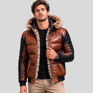 Puede incluir: Chaqueta de cuero marrón y negro con capucha forrada de piel. La chaqueta presenta un diseño acolchado en la parte delantera y las mangas, con detalles negros en los hombros y las mangas. Tiene cierre de cremallera y dobladillo acanalado negro.