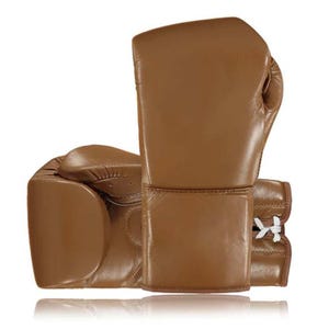 May include: A pair of brown leather boxing gloves. The gloves are a solid, warm brown color with a smooth texture. The cuffs have white laces. The gloves are designed for protection and impact absorption during training or competition.