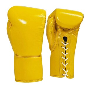May include: A pair of bright yellow boxing gloves. The gloves are made of leather and have a glossy finish. White laces secure the gloves. The gloves are designed for protection and impact absorption during boxing.