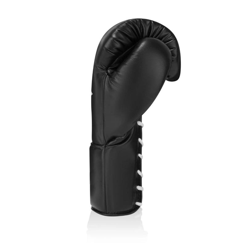 May include: A single black boxing glove with white laces. The glove is made of leather and is designed for protection during boxing or other combat sports. The glove is shown against a white background.