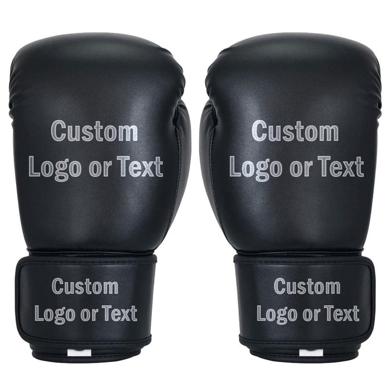 May include: Pair of black boxing gloves with the text "Custom Logo or Text" printed in silver. The gloves are made of a smooth material and have a wrist strap with the same text. Ideal for personalized gifts or training.