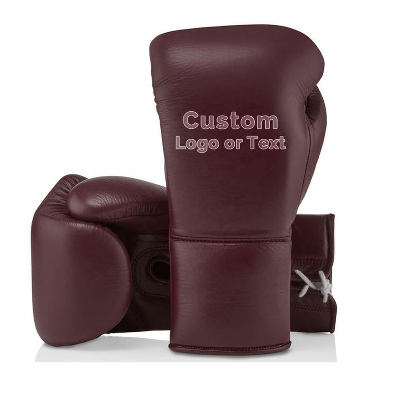 May include: Burgundy leather boxing gloves with the text "Custom Logo or Text" printed on the side. The gloves are shown on a white background. The gloves have white laces and are designed for boxing.