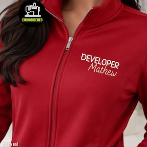 Può includere: Una tazza di ceramica bianca con manico nero e la scritta "But First, Coffee" in grassetto nero. La tazza è posta su uno sfondo sfocato, che suggerisce un'ambientazione accogliente. La tazza è alta circa 10 cm.