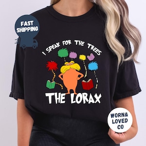 May include: Black t-shirt featuring a colorful illustration of The Lorax with the text "I Speak for the Trees" and "The Lorax". The design includes colorful trees and open books.