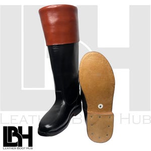 Könnte beinhalten: Ein Paar schwarze Reitstiefel aus Leder mit braunem Lederoberteil. Die Stiefel haben eine spitze Zehenpartie und einen niedrigen Absatz. Die Stiefel sind Größe 8.