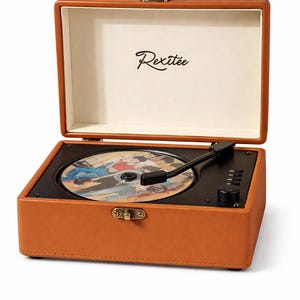 Peut inclure: Un tourne-disque portable orange avec une platine noire et un disque en place. Le lecteur a un couvercle à charnière et une fermeture à fermoir. Le nom de la marque "Rexitee" est imprimé à l'intérieur du couvercle.