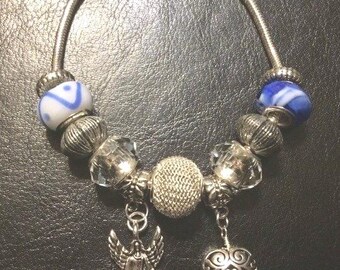 Pulsera de cristal con dijes de ángeles y corazones