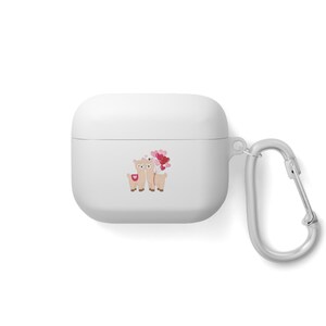 Könnte beinhalten: Weißes AirPods-Etui mit silbernem Karabinerhaken. Das Etui zeigt eine Cartoon-Illustration von zwei Lamas, die herzförmige Luftballons halten. Die Lamas sind hellbraun mit rosa Akzenten, und die Ballons sind rot und rosa.