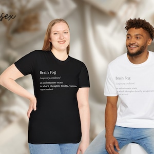 Puede incluir: Dos camisetas unisex, una negra y otra blanca, con el texto "Brain Fog" y su definici&oacute;n. La camiseta negra la lleva una persona de piel clara, y la camiseta blanca una persona de piel oscura. Ambas son de manga corta.
