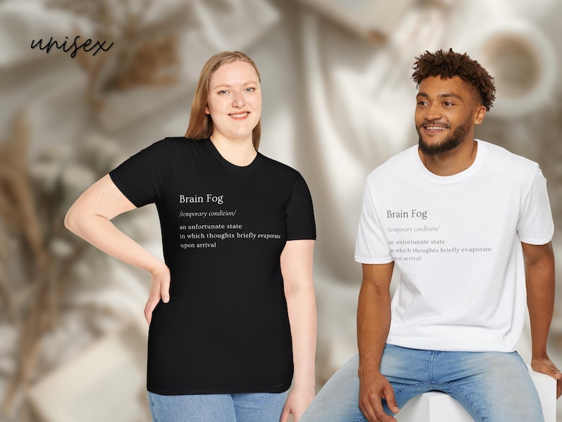 Puede incluir: Dos camisetas unisex, una negra y otra blanca, con el texto "Brain Fog" y su definici&oacute;n. La camiseta negra la lleva una persona de piel clara, y la camiseta blanca una persona de piel oscura. Ambas son de manga corta.