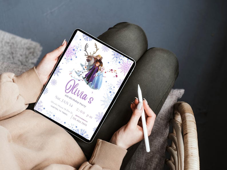 May include: A digital tablet displays a birthday party invitation with a Frozen theme. The invitation features the name "Olivia's" in purple script, along with the date, time, and location. The design includes snowflakes and characters from the movie.