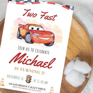 K&ouml;nnte beinhalten: Eine wei&szlig;e Einladungskarte mit einer roten Rennwagen-Illustration und dem Text "Two Fast". Die Karte lautet "Feiern Sie mit uns Michael, der 2 Jahre alt wird!" mit Datums- und Zeitangaben. Enth&auml;lt Grafiken von Leitkegeln und Ampeln.