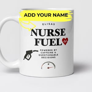 Puede incluir: Taza de cerámica blanca con el texto "NURSE FUEL" en negro, un corazón rojo y un gráfico de surtidor de gasolina. La taza también incluye la frase "Powered by Caffeine & Questionable Decisions" y un indicador de combustible. La palabra "ELISAS" está encima del texto.