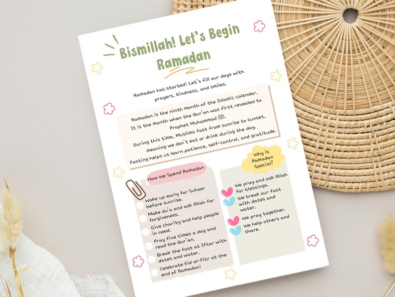 May include: A white paper with the text "Bismillah! Let's Begin Ramadan" and information about Ramadan. The paper includes text about fasting, prayers, and the importance of kindness. Decorative elements include pink and yellow stars and flowers.