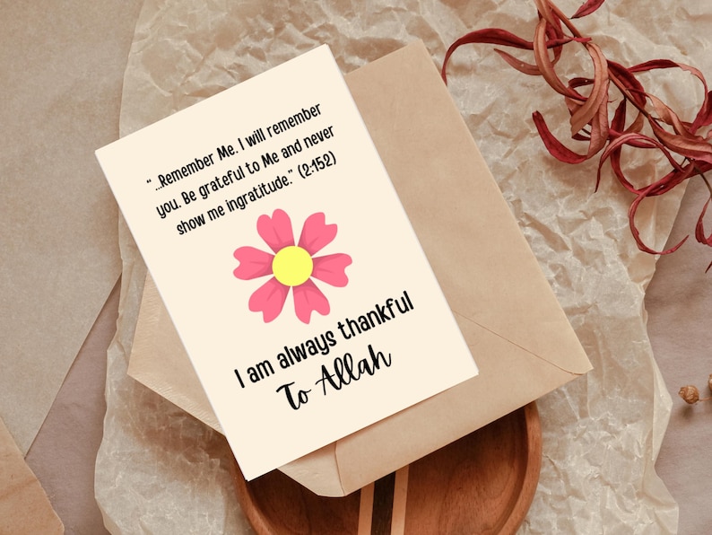 K&ouml;nnte beinhalten: Eine Gru&szlig;karte mit einer rosa Blume und einem gelben Zentrum sowie dem Text "I am always thankful To Allah". Die Karte liegt auf einem braunen Umschlag, mit einem Text aus dem Koran.