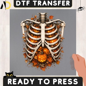 May include: A DTF transfer ready to press featuring a human rib cage filled with glowing orange jack-o'-lantern pumpkins and autumn leaves. The design is set against a gray background with the text DTF TRANSFER and READY TO PRESS.