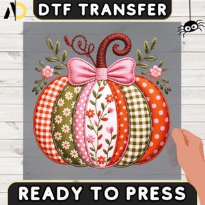 Peut inclure: Motif DTF TRANSFER représentant une citrouille patchwork avec un nœud rose et des détails floraux. La citrouille présente des sections à pois orange, à carreaux vichy verts et à motifs floraux. Le texte "READY TO PRESS" est en bas.