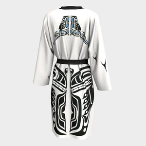 Chaqueta o bata con diseño de águila y cuervo con Thunderbird, de Tlingit Artist, en blanco y negro con detalles en azul.