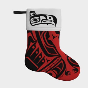 Puede incluir: Calcetín de Navidad rojo con un diseño estilizado en blanco y negro de un pájaro con pico y ojos. El calcetín tiene un puño blanco con un diseño de pájaro estilizado en blanco y negro.