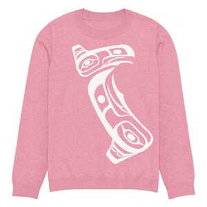 May include: A pale pink crew neck sweatshirt with a white, stylised bird design. The graphic is a bold, abstract representation of a bird, with intricate details. The sweatshirt has long sleeves and a classic fit, suitable for casual wear.