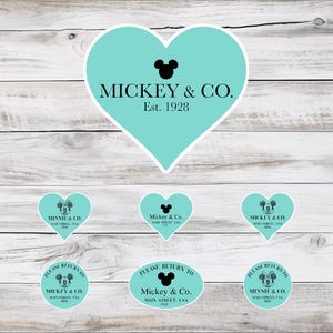 以下が含まれることがあります： 「MICKEY & CO. Est. 1928」の文字とミッキーマウスのシルエットが描かれたステッカーのコレクション。ステッカーはハートや楕円など様々な形で、色はターコイズブルーです。背景は明るい木目模様です。