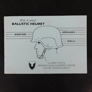 May include: A light blue pamphlet with the text "this is your BALLISTIC HELMET" and a line drawing of a helmet and a person's profile. The pamphlet also includes the text "MORTARS", "GRENADES", and "SHELLS".