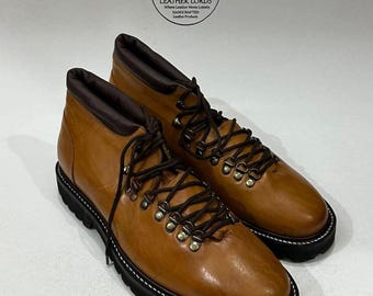 May include: A pair of brown leather boots with dark brown laces and metal eyelets. The boots have a black sole with white stitching and a dark brown collar. The boots are labeled "Leather Lords".