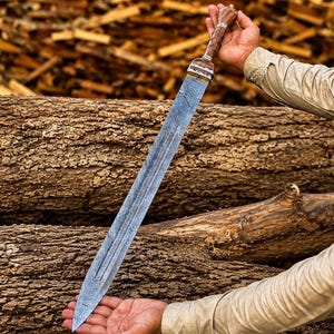 May include: A double-edged sword with a patterned Damascus steel blade featuring a central fuller. The hilt is crafted from polished brown wood with intricate silver-colored metal accents at the pommel and guard, creating a distinct contrast.