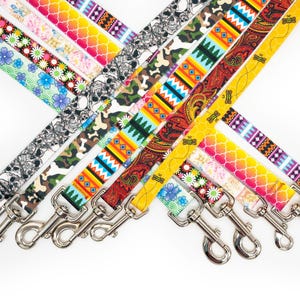 May include: A collection of colorful dog leashes with various patterns, including floral, skull, camouflage, and geometric designs. Each leash has a silver metal clasp for easy attachment. The leashes are displayed against a white background.