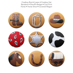 Könnte beinhalten: Neun runde, bemalte Holzornamente mit Western-Motiv. Die Ornamente zeigen einen Cowboystiefel, ein Lasso, einen Cowboyhut, ein Bandana, ein Sheriffstern, einen Kuhflecken, ein Pferd, ein Hufeisen und einen Planwagen.