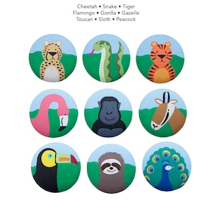 Könnte beinhalten: Neun bunte runde Knöpfe mit verschiedenen Tierillustrationen. Die Tiere sind ein Gepard, eine Schlange, ein Tiger, ein Flamingo, ein Gorilla, eine Gazelle, ein Tukan, ein Faultier und ein Pfau.