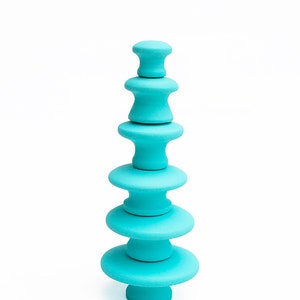 Pode incluir: Uma pilha de blocos de madeira azul turquesa em forma de árvore de Natal.