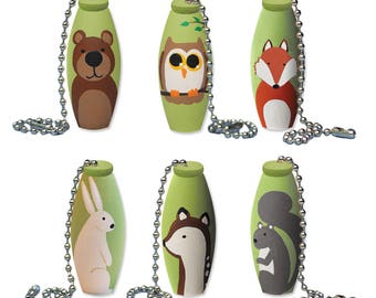 May include: Six green wooden fan pull ornaments with different animal designs. The animals are a bear, owl, fox, rabbit, deer, and squirrel.