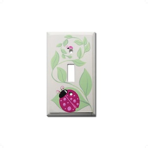 May include: A white light switch cover with a hand-painted design of pink ladybugs on green vines.